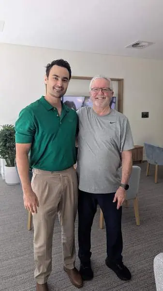 Stephen standing with his physiotherapist